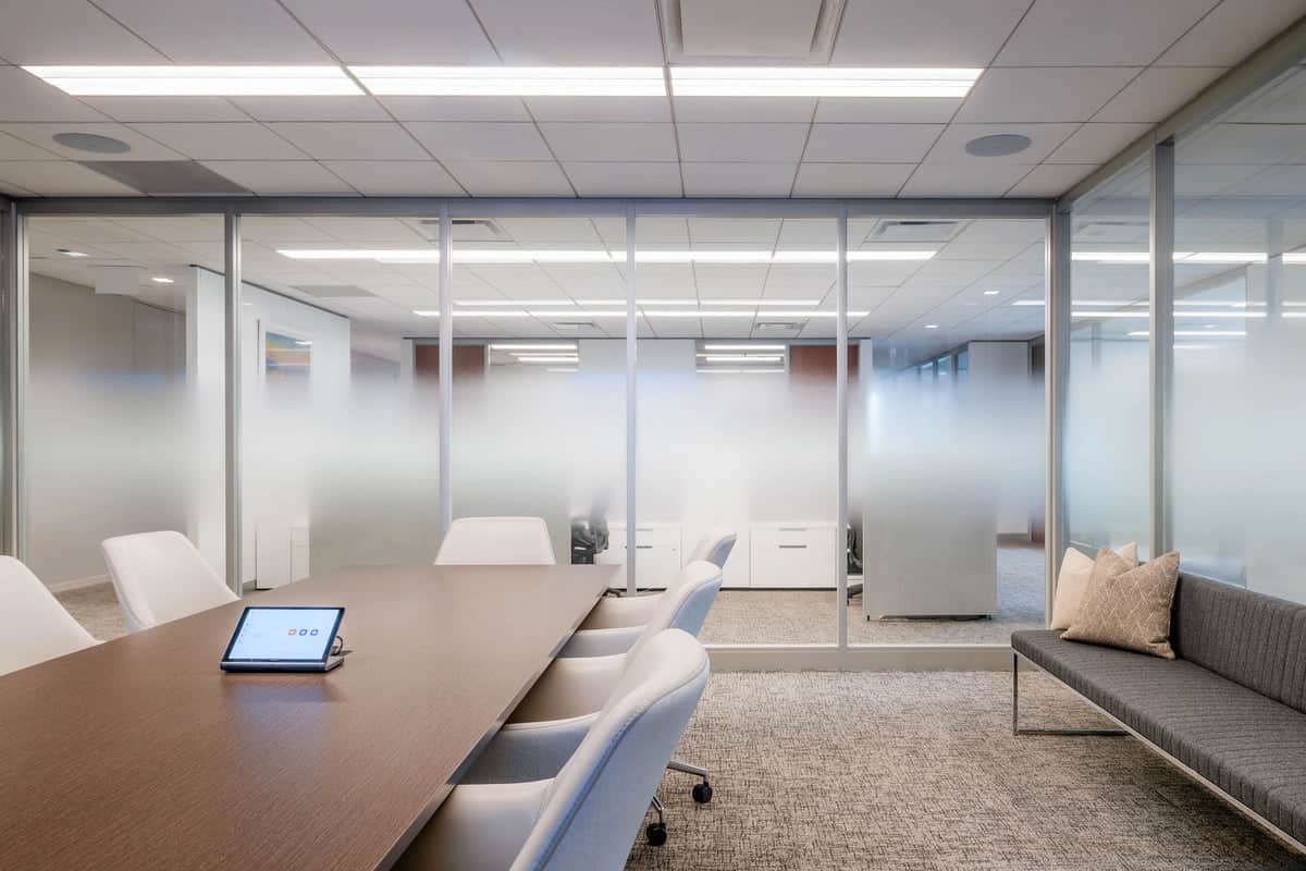 Executive boardroom with frosted glass walls and upholstered conference seating